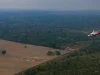 Helikopter terbang di atas hutan Amazon dan lahan terbuka di Autazes, Brasil