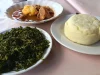 Ilustrasi sepiring ugali dengan sayur hijau dan semangkuk tumbukiza di Mombasa, Kenya