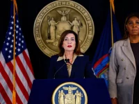Gubernur New York Kathy Hochul berbicara di podium didampingi Letitia James