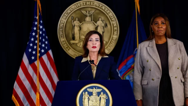 Gubernur New York Kathy Hochul berbicara di podium didampingi Letitia James