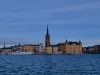 Deretan bangunan tepi air di Stockholm, Swedia, di bawah langit biru