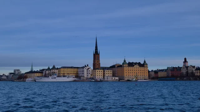 Deretan bangunan tepi air di Stockholm, Swedia, di bawah langit biru