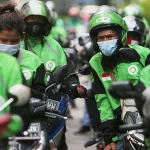 Ilustrasi para pengemudi ojek daring bermasker di jalan