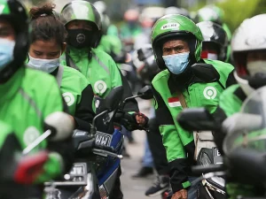 Ilustrasi para pengemudi ojek daring bermasker di jalan