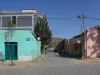 Ilustrasi jalan berbatu dengan rumah bercat hijau dan merah muda di kota lama Mekelle, Ethiopia