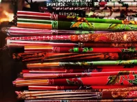 Lembaran kain batik berwarna merah dan hijau tersusun bertumpuk di rak sebuah toko