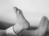 Ilustrasi sepasang kaki bayi baru lahir dengan gelang identitas di pergelangan kaki