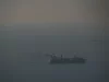 Kapal kargo berlayar di perairan Teluk yang berkabut menuju Selat Hormuz, terlihat dari Dubai