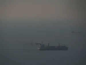 Kapal kargo berlayar di perairan Teluk yang berkabut menuju Selat Hormuz, terlihat dari Dubai