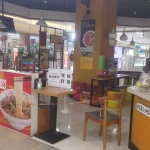 Kedai mi kecil di pusat belanja Shanghai dengan meja dipasangi garis pembatas pada masa pandemi