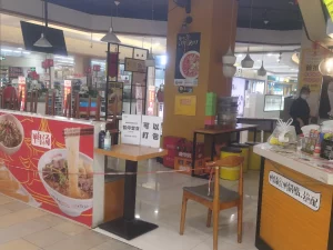 Kedai mi kecil di pusat belanja Shanghai dengan meja dipasangi garis pembatas pada masa pandemi