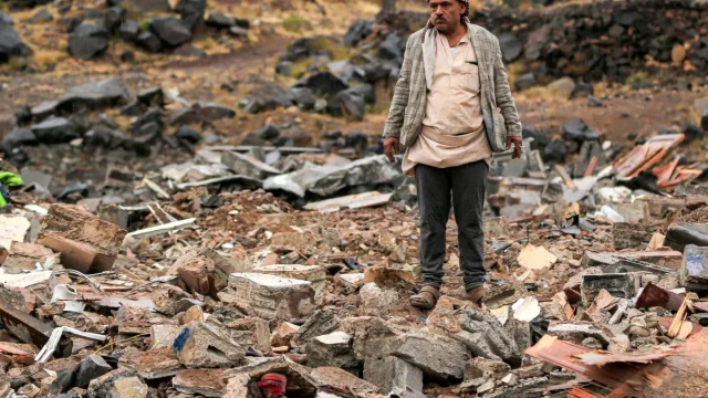 Seorang pria memeriksa reruntuhan akibat serangan udara di Distrik Asr, Sanaa, Yaman