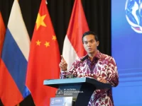 Ketua Umum Kadin Indonesia Anindya Novyan Bakrie berbicara di podium berlatar bendera sejumlah negara