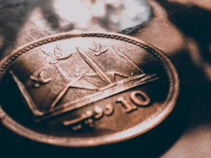 Ilustrasi koin 10 rupee Pakistan bergambar masjid dipotret dekat di bawah berkas cahaya