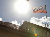 Bendera Rusia berkibar di atas atap gedung Konsulat Jenderal Rusia di bawah langit cerah