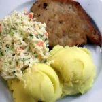 Ilustrasi sepiring kotlet schabowy khas Polandia dengan kentang tumbuk dan salad kubis, hidangan kantin