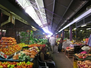 Tumpukan tomat, apel, jeruk, dan sayuran di lapak lorong pasar buah Durban, Afrika Selatan