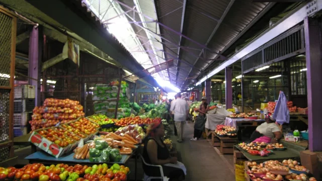 Tumpukan tomat, apel, jeruk, dan sayuran di lapak lorong pasar buah Durban, Afrika Selatan