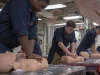 Ilustrasi pelaut Angkatan Laut AS berlatih menekan dada manekin dalam kelas CPR di kapal USS McCampbell