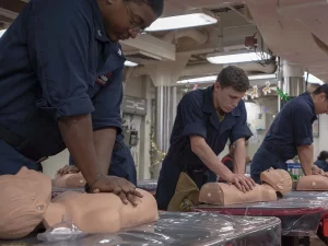 Ilustrasi pelaut Angkatan Laut AS berlatih menekan dada manekin dalam kelas CPR di kapal USS McCampbell