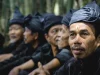 Ilustrasi deretan lelaki Kajang berpakaian serba hitam duduk berjajar di Bulukumba, Sulawesi Selatan