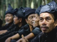 Ilustrasi deretan lelaki Kajang berpakaian serba hitam duduk berjajar di Bulukumba, Sulawesi Selatan