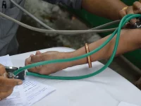 Lengan seorang warga diperiksa tekanan darahnya pada pemeriksaan kesehatan di Howrah, India