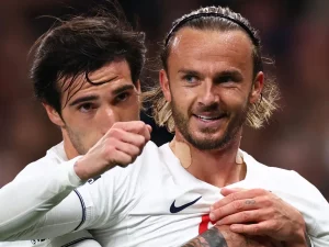 James Maddison tersenyum dirangkul rekan setim usai mencetak gol untuk Tottenham