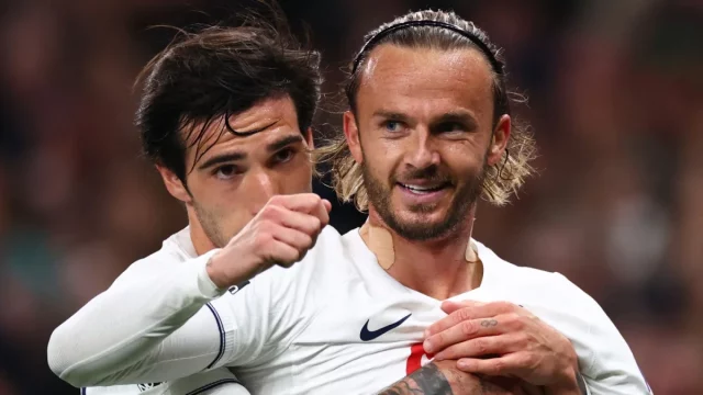 James Maddison tersenyum dirangkul rekan setim usai mencetak gol untuk Tottenham