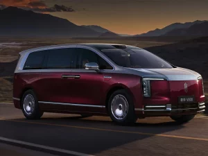 Mobil listrik Maextro V800 berwarna merah marun melaju di jalan pegunungan