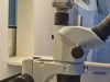 Ilustrasi mikroskop stereo putih berlensa okuler hitam di meja kerja laboratorium bayi tabung