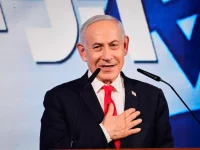 Benjamin Netanyahu tersenyum sambil meletakkan tangan di dada saat berpidato