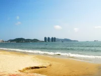 Pantai berpasir di Teluk Sanya, Hainan, dengan deretan menara hotel di kejauhan