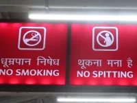 Papan lampu bertulisan No Smoking dan No Spitting di stasiun kereta Varanasi, India