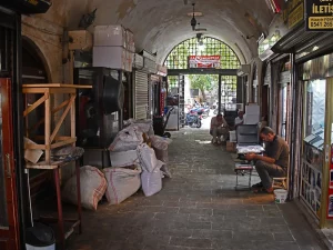 Ilustrasi lorong pasar beratap lengkung dengan kios dan karung barang di Şanlıurfa, Turki