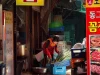 Ilustrasi pedagang bermasker menyiapkan daun bawang di kios pasar berpapan nama aksara Korea, Korea Selatan