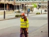 Ilustrasi pekerja jalan berompi reflektif kuning dan bermasker di jalan kota Perth, Australia Barat
