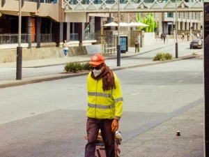 Ilustrasi pekerja jalan berompi reflektif kuning dan bermasker di jalan kota Perth, Australia Barat