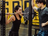 Ilustrasi pelatih pribadi mengawasi klien perempuan melakukan squat dengan barbel di gym