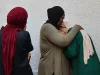 Tiga perempuan Palestina berpelukan dan berduka di dekat dinding Rumah Sakit Al-Shifa