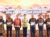 Tujuh orang berbatik berfoto memegang buku pada peluncuran RP3I OJK di Bali