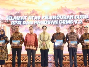 Tujuh orang berbatik berfoto memegang buku pada peluncuran RP3I OJK di Bali