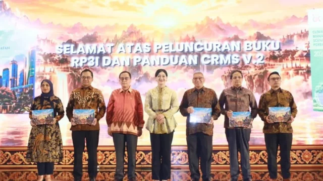 Tujuh orang berbatik berfoto memegang buku pada peluncuran RP3I OJK di Bali