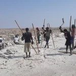 Para pekerja Afar mencungkil dan menumpuk balok garam di dataran garam wilayah Afar, Etiopia