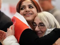 Dua pendukung Forever Canadian berpelukan saat menyaksikan hasil referendum Alberta di Edmonton