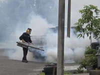 Petugas menyemprotkan asap pembasmi nyamuk Aedes di permukiman Sandakan, Sabah, Malaysia