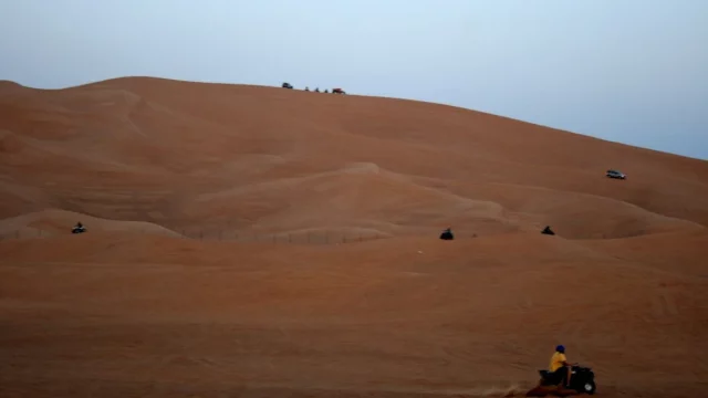 Ilustrasi motor ATV di lereng bukit pasir jingga gurun Dubai, Uni Emirat Arab