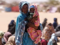 Seorang perempuan pengungsi Sudan menggendong bayi di kamp Oure Cassoni, Chad
