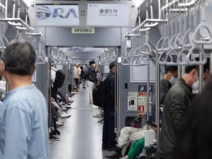 Ilustrasi penumpang berdiri dan duduk di dalam gerbong kereta bawah tanah Seoul, Korea Selatan