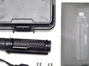 Ilustrasi perangkat rokok elektrik hitam beserta kotak dan kabel pengisi daya di latar putih